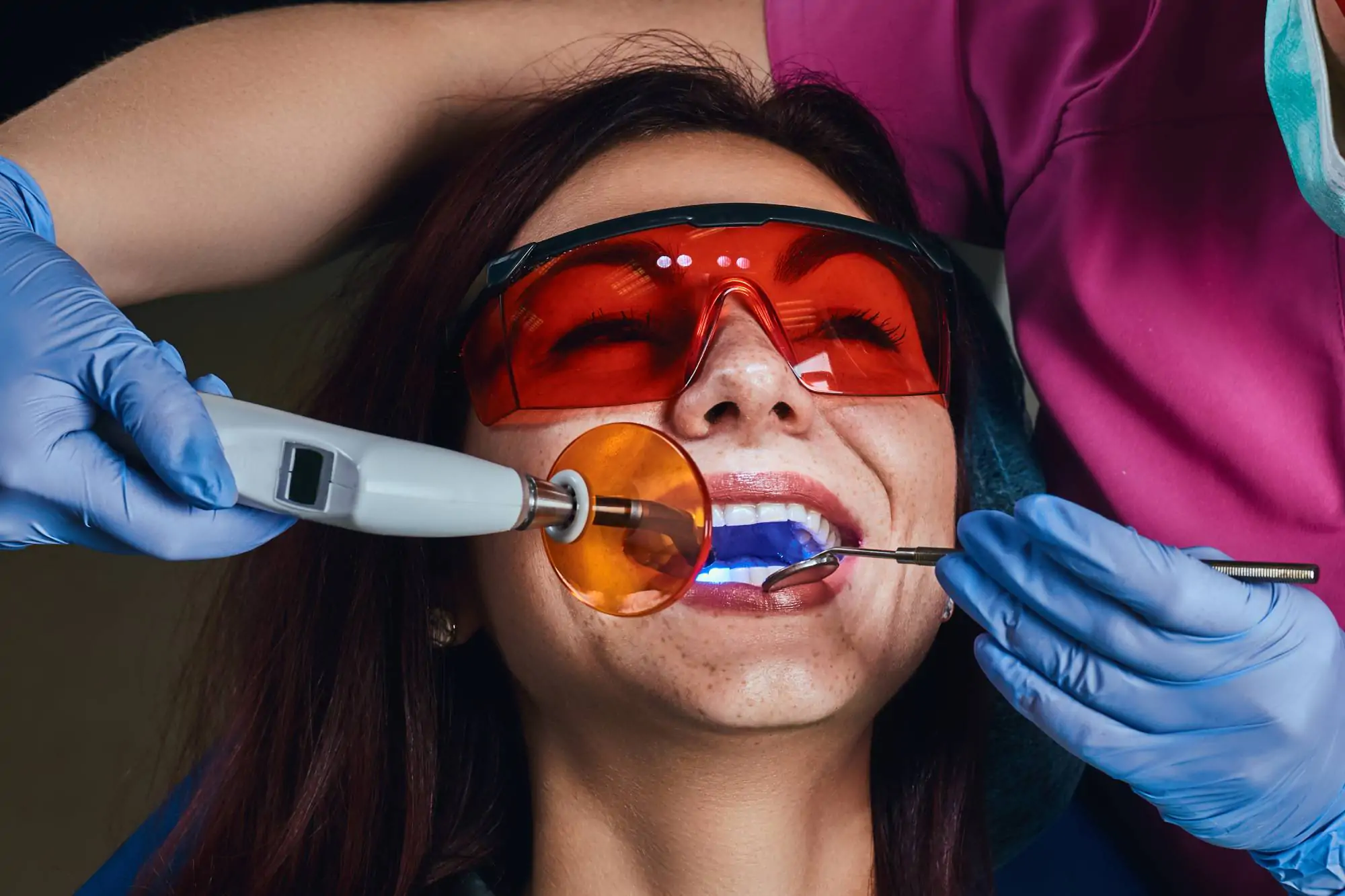 Paciente usando óculos de proteção durante procedimento de clareamento dental a laser na clínica Ferdinand Odontologia, na Tijuca, Rio de Janeiro